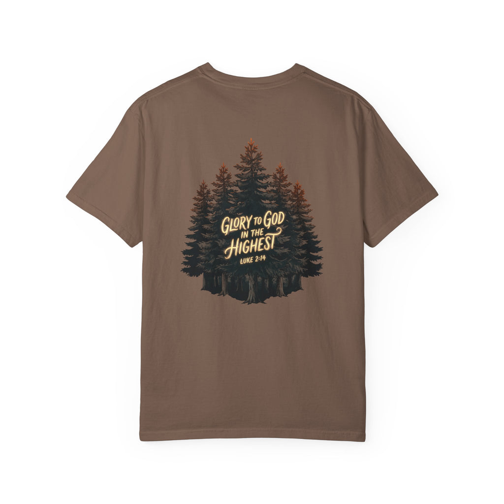 A brown short-sleeve t-shirt with a graphic of pine trees and the text 'GLORY TO GOD IN THE HIGHEST LIKE 2 CH 5:14' printed on the chest, shown against a plain white background.